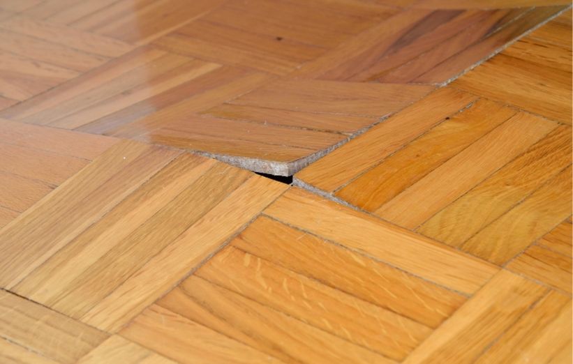 Plancher de bois déformé par le gauchissement causé par un excès d'humidité.